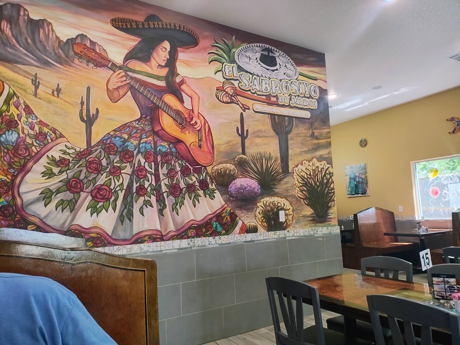 Hand-painted mural of a mariachi guitarist inside El Sabrosito de Jalisco